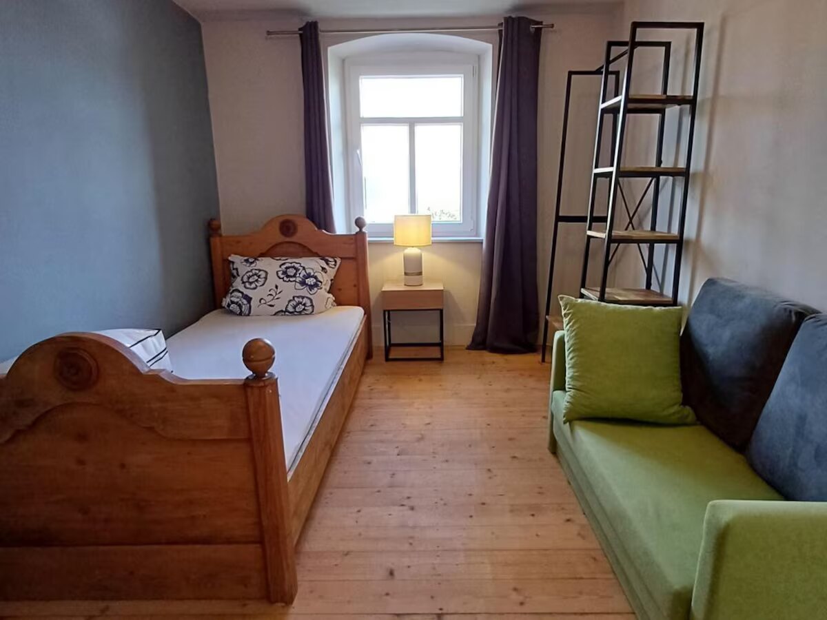 Helles Gästezimmer mit Einzelbett und Schlafsofa
